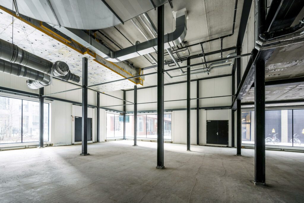 Leegstaand bedrijfs- of winkelpand aan de Pieter Goosstraat met zichtbare metalen constructie en ventilatiebuizen.